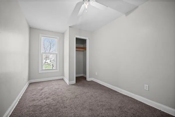 an empty room with windows and closet