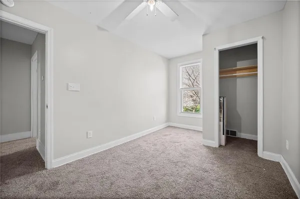an empty room with closet and windows