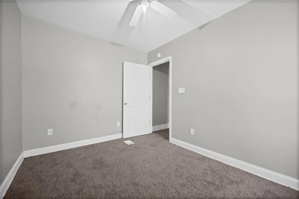 an empty room with closet and a chandelier fan