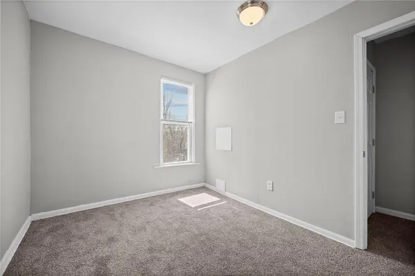 an empty room with windows and closet
