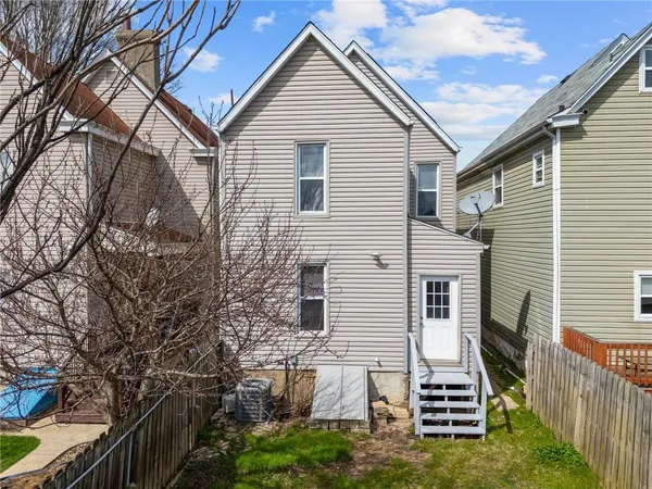 a view of a house with backyard and wooden fence