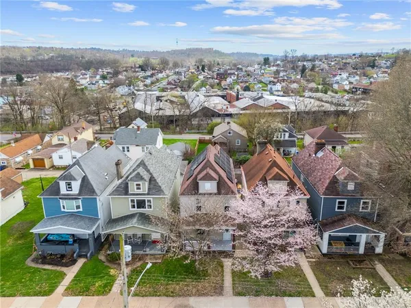 an aerial view of residential houses with outdoor space and trees