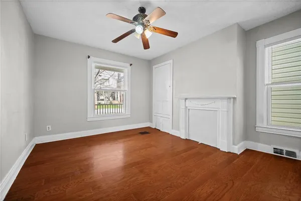 a view of empty room with window and ceiling fan