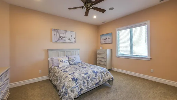 a spacious bedroom with a balcony a bed and a chandelier