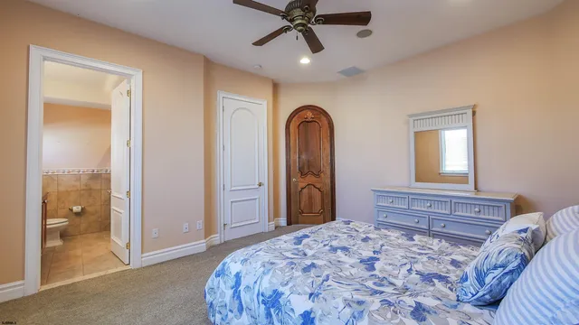 a bedroom with a large bed and a chandelier