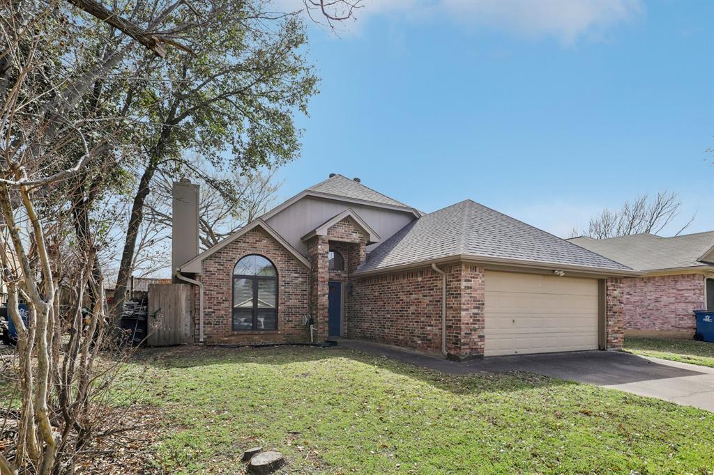a front view of a house with a garden and trees