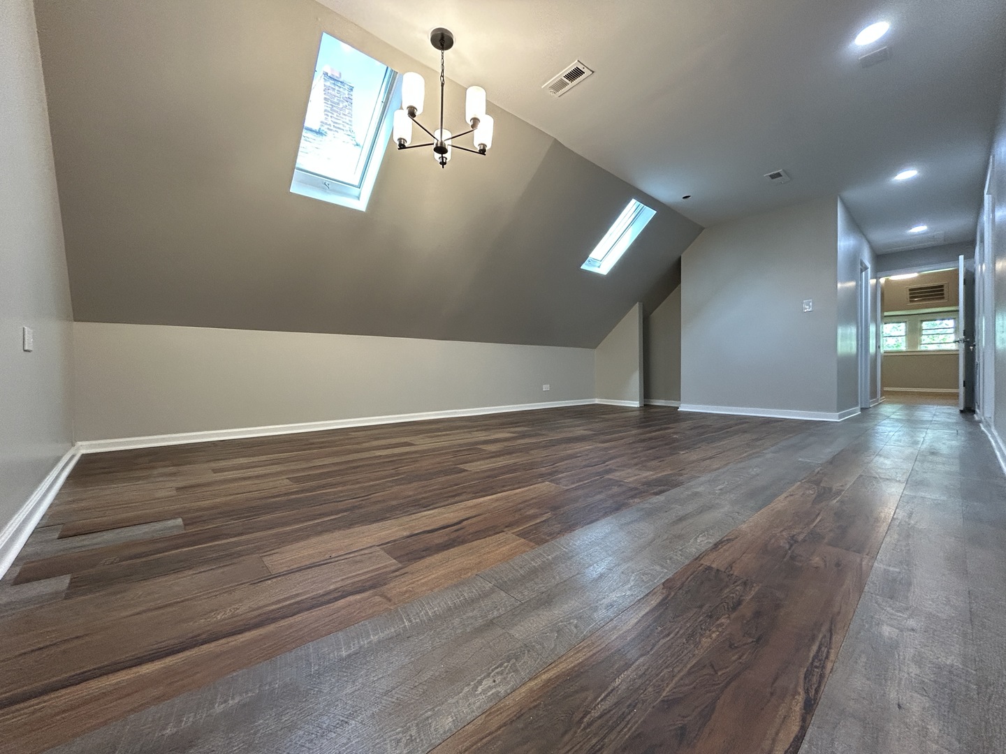 4834 North Ridgeway Avenue, Unit 3 Chicago, IL 60625 - Photo 3 of 12 an empty room with wooden floor and windows
