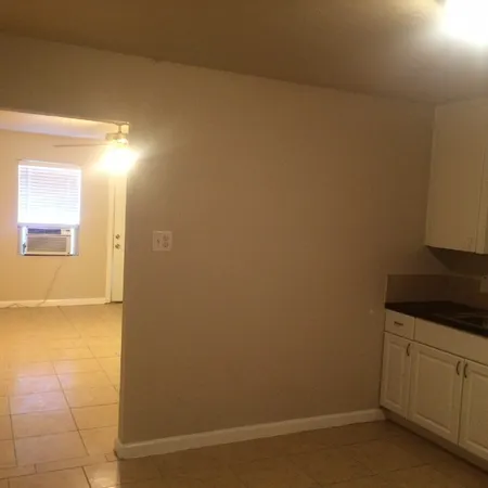 a kitchen with granite countertop white cabinets and black appliances