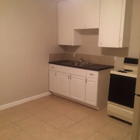 a kitchen with granite countertop white cabinets and black appliances