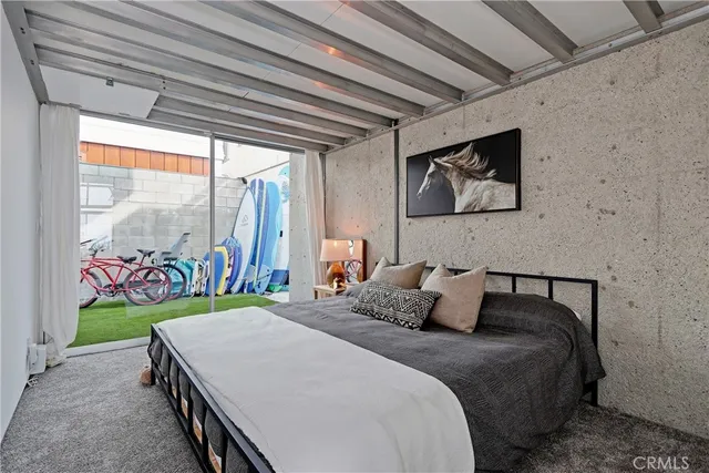 a bedroom with a bed a dresser and potted plants