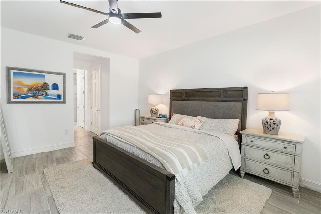 14837 Windward Lane Naples, FL 34114 - Photo 15 of 39 a bedroom with a bed and a night stand
