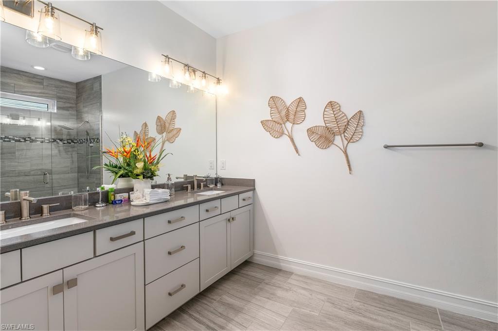 14837 Windward Lane Naples, FL 34114 - Photo 16 of 39 a bathroom with a double vanity sink and a mirror