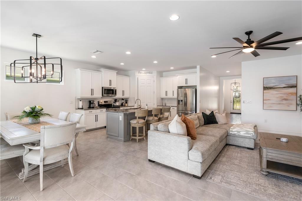 14837 Windward Lane Naples, FL 34114 - Photo 4 of 39 a living room with couches a kitchen island with couches and cabinets