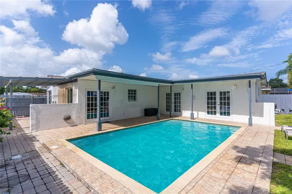 a view of a house with pool and a yard