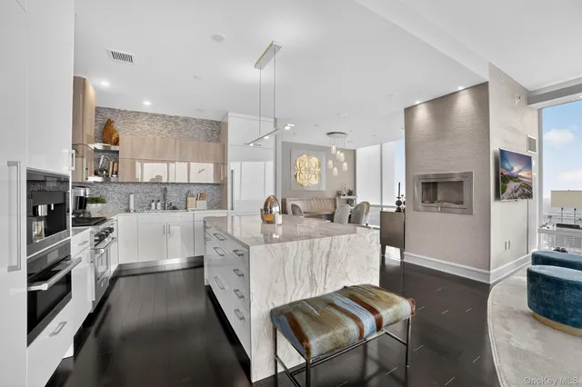 a large white kitchen with cabinets a sink a window and stainless steel appliances