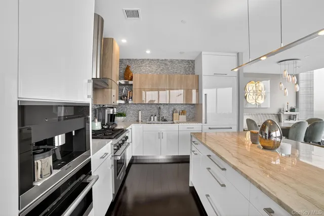 a large kitchen with stainless steel appliances lots of counter space and a sink
