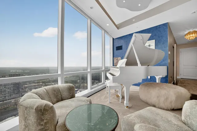 a living room with furniture and a floor to ceiling window