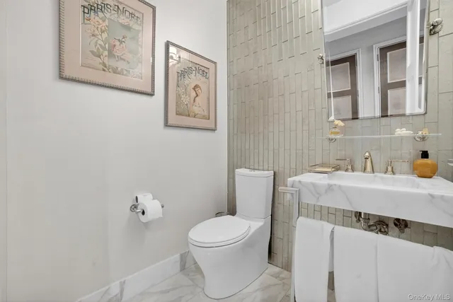 a bathroom with a toilet a sink and mirror