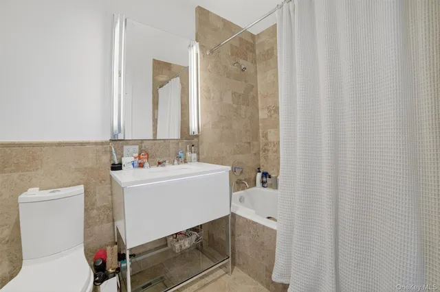 a bathroom with a sink a toilet and shower curtain