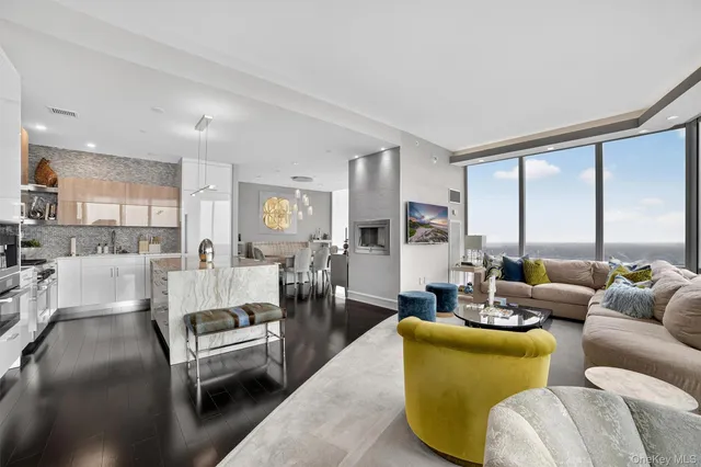 a living room with furniture wooden floor and a large window