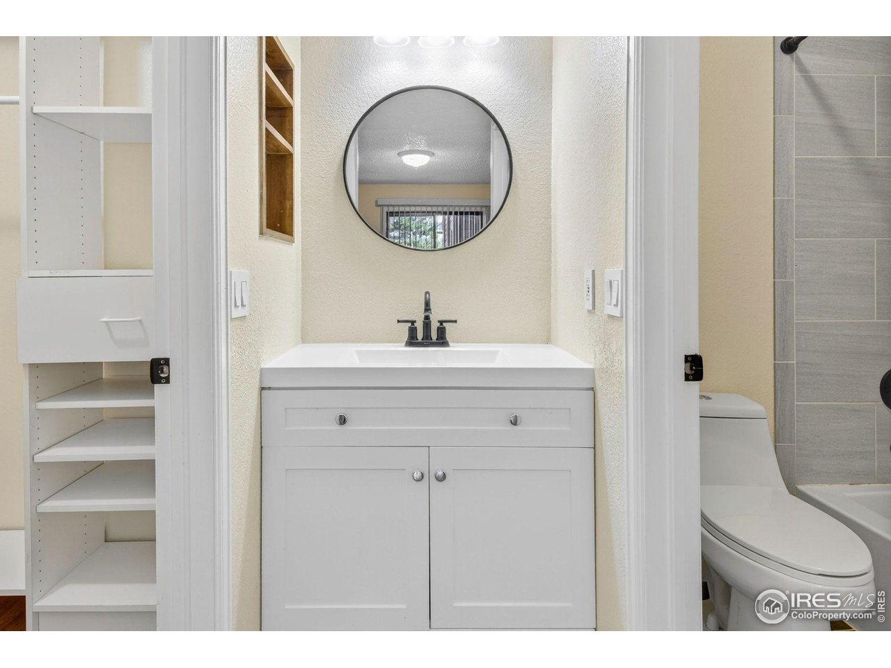 9407 West 89th Circle Broomfield, CO 80021 - Photo 19 of 32 a bathroom with a toilet a sink and a mirror