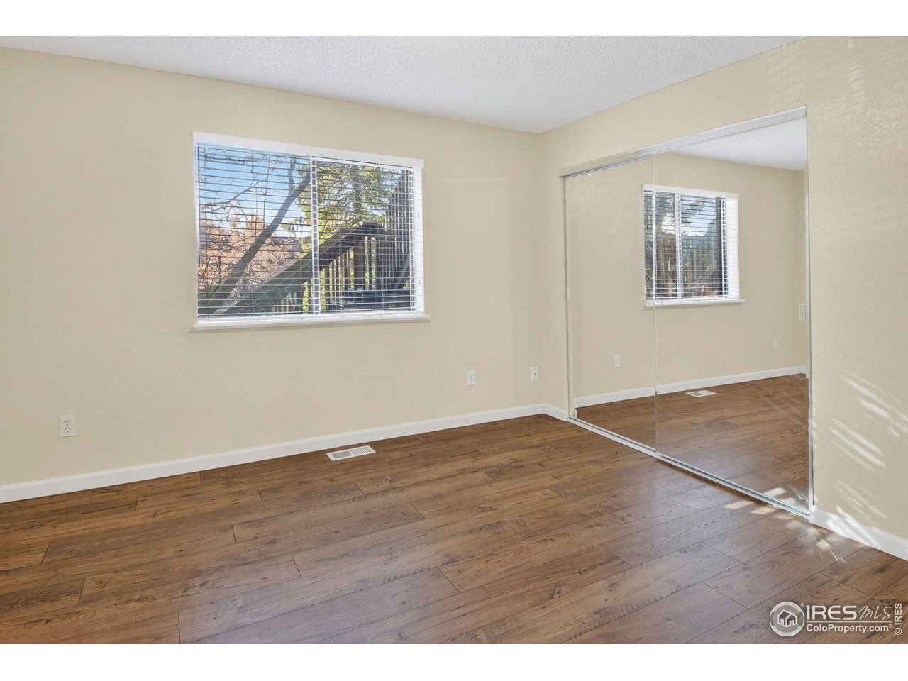 9407 West 89th Circle Broomfield, CO 80021 - Photo 21 of 32 an empty room with wooden floor and windows