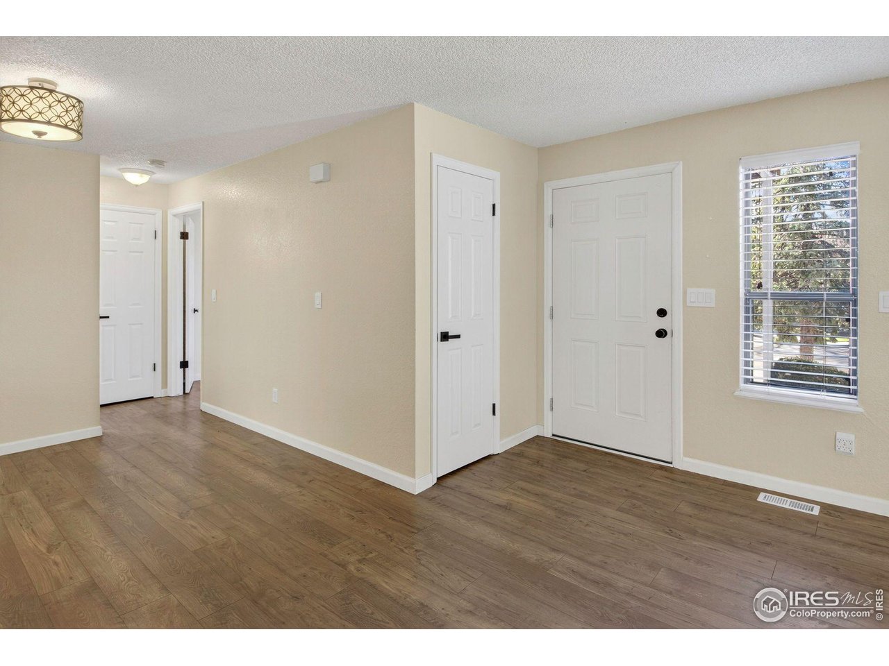9407 West 89th Circle Broomfield, CO 80021 - Photo 9 of 32 a view of an empty room with wooden floor and a window