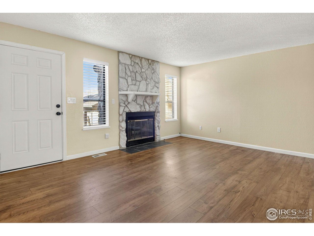 9407 West 89th Circle Broomfield, CO 80021 - Photo 10 of 32 a view of empty room with wooden floor and fireplace