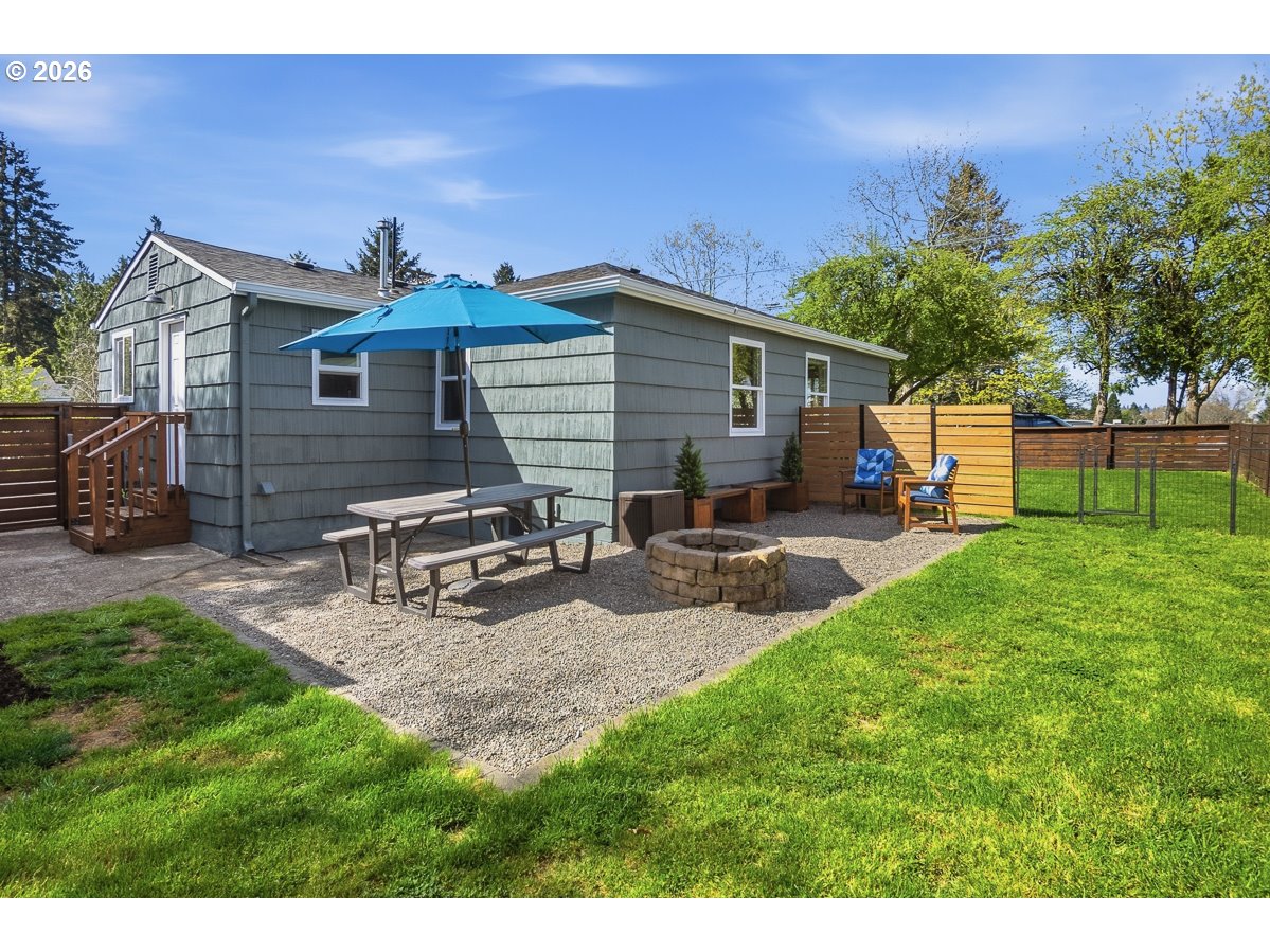 622 Southeast 111th Avenue Portland, OR 97216 - Photo 24 of 34 a view of a backyard with table and chairs potted plants and a wooden fence