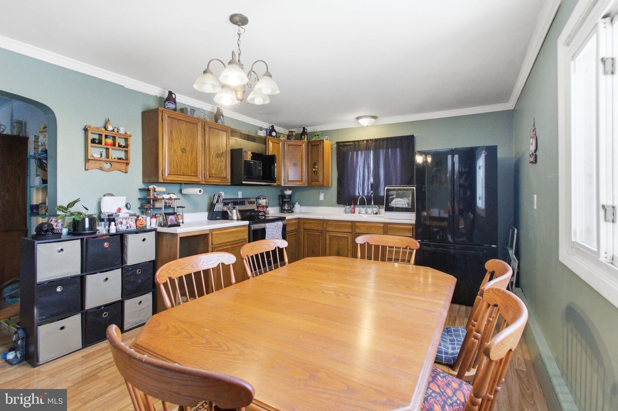 624 Decatur Street Philipsburg, PA 16866 - Photo 8 of 19 a kitchen with stainless steel appliances granite countertop a stove a refrigerator a sink dishwasher a dining table and chairs with wooden floor