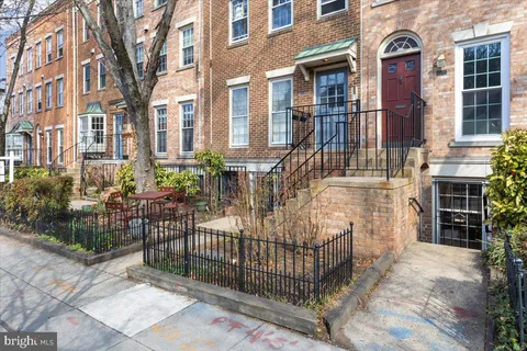 a view of a brick house with large windows and a yard