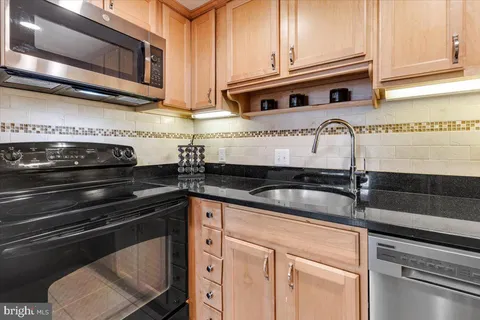 a kitchen with stainless steel appliances granite countertop a sink and cabinets
