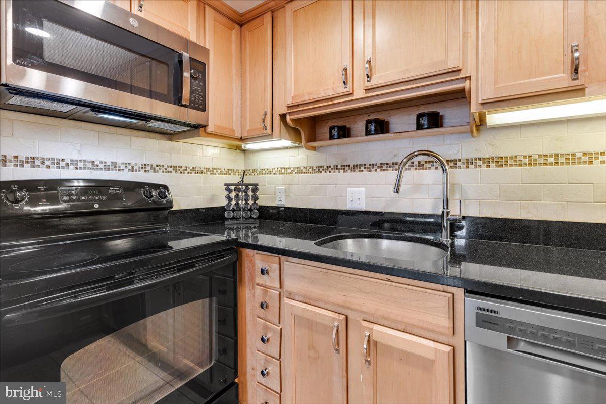 1949 Calvert Street Northwest, Unit E Washington, DC 20009 - Photo 11 of 29 a kitchen with stainless steel appliances granite countertop a sink and cabinets