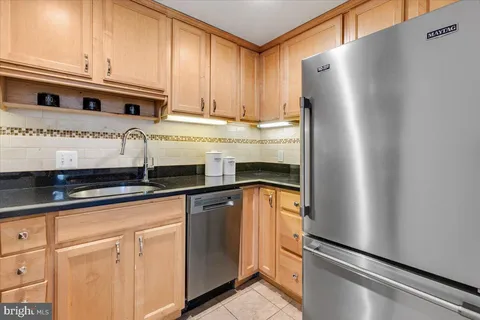 a kitchen with stainless steel appliances granite countertop a refrigerator and a sink