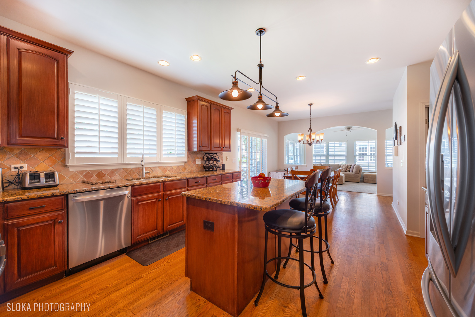 1170 Ridgewood Circle Lake In The Hills, IL 60156 - Photo 8 of 33 a kitchen with stainless steel appliances granite countertop wooden floor dining table and chairs