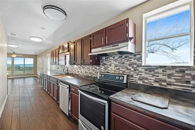 a kitchen with stainless steel appliances granite countertop a stove and a sink