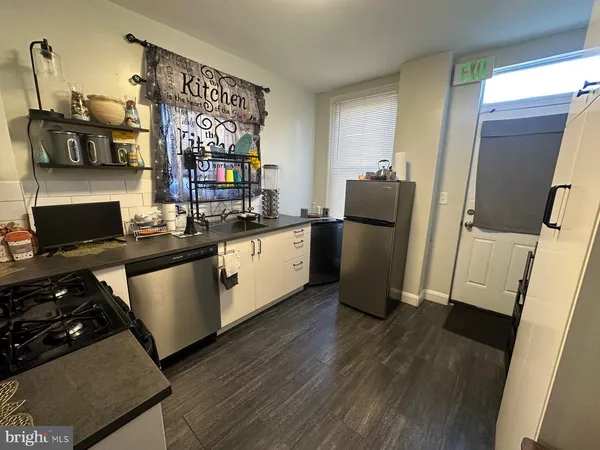 a kitchen with stainless steel appliances granite countertop a refrigerator stove and sink