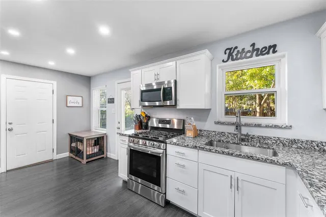 a kitchen with stainless steel appliances granite countertop a stove and a sink