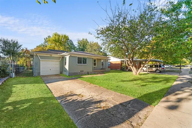 a front view of a house with a yard and trees
