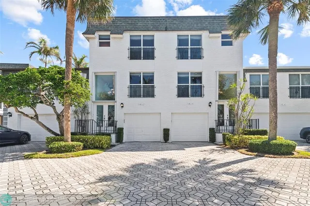 a view of a brick house with a yard and plants