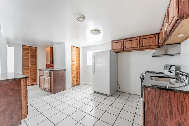 a kitchen with stainless steel appliances granite countertop a refrigerator a stove and a sink with cabinets