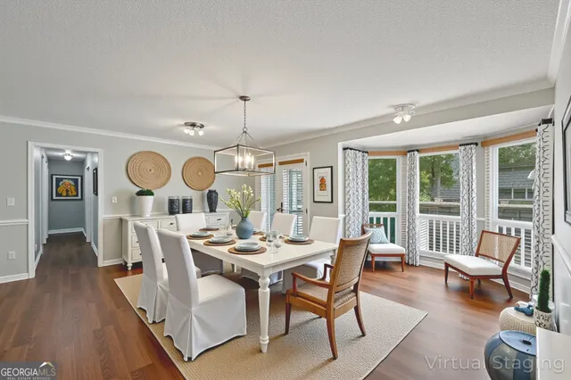 a dining room with wooden floor a chandelier fan a wooden table and chairs