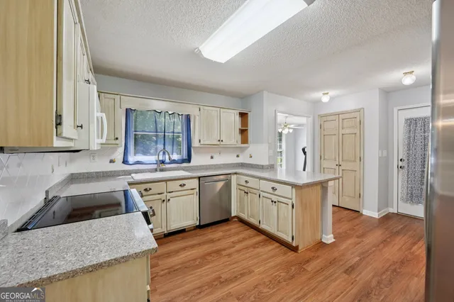 a kitchen with granite countertop a sink stove and refrigerator