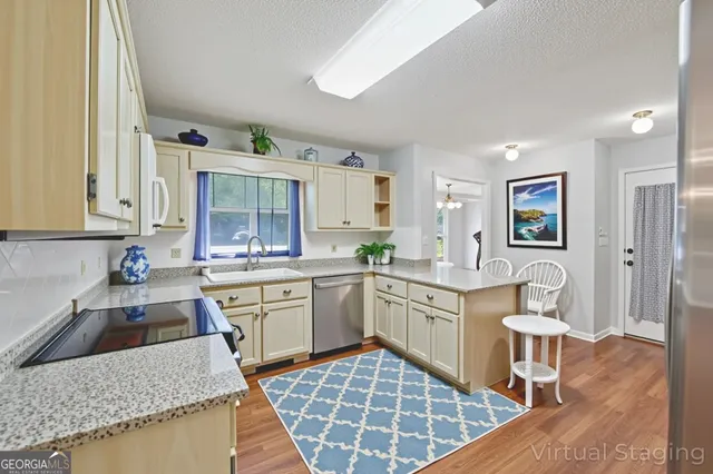a large kitchen with kitchen island a sink stove and cabinets