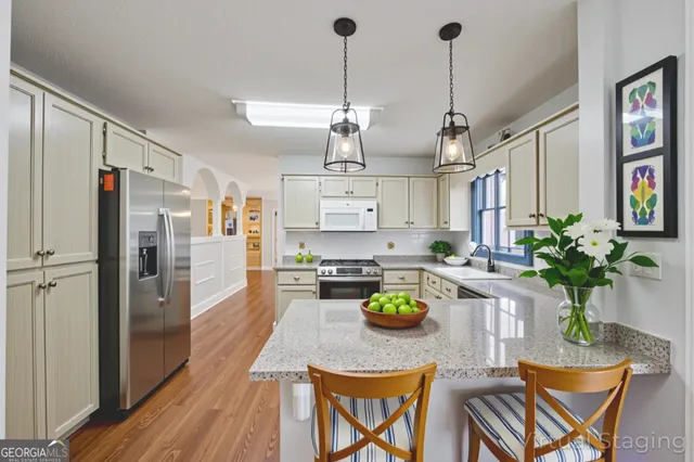 a kitchen with sink refrigerator and dining table