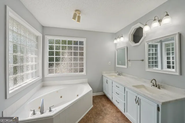 a bathroom with a tub sink and mirror