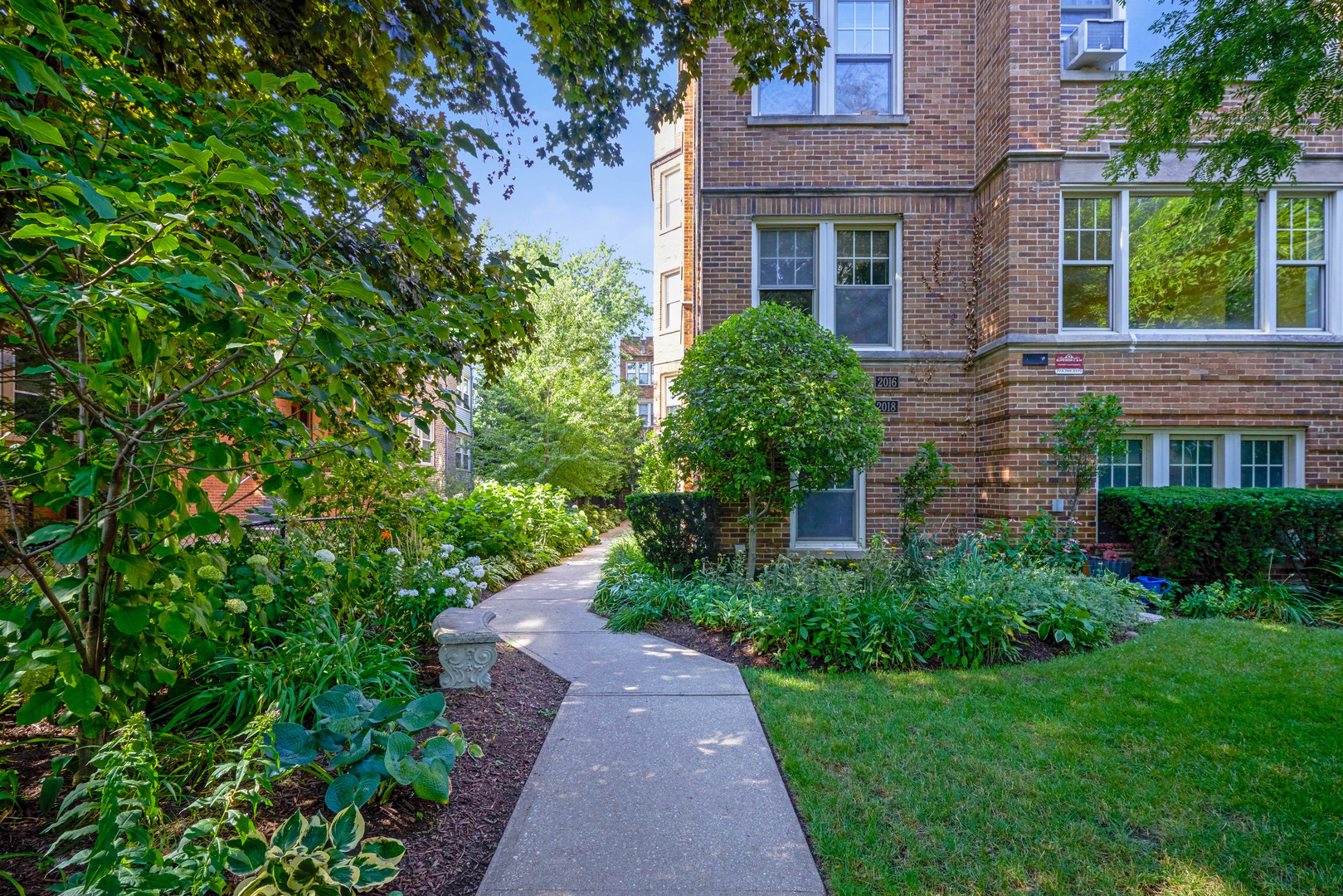 2018 West Greenleaf Avenue, Unit 1F Chicago, IL 60645 - Photo 2 of 12 a front view of a building with a garden