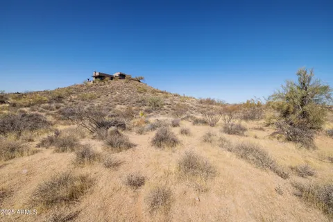 a view of a dry yard with mountains in the background