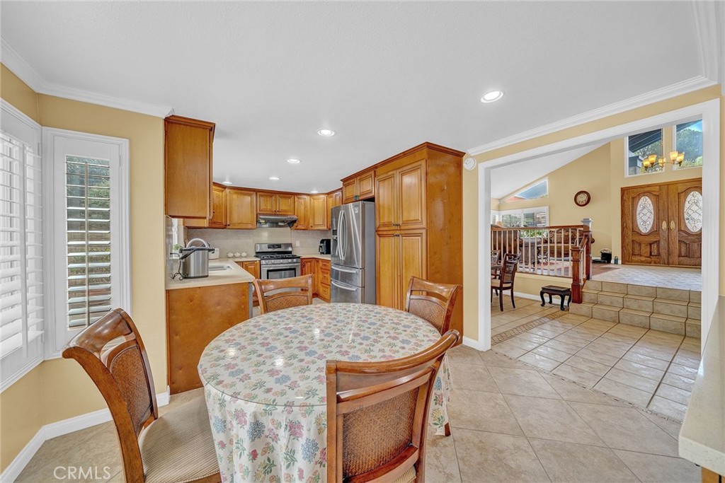 23419 Sandridge Road Diamond Bar, CA 91765 - Photo 28 of 51 a kitchen with stainless steel appliances granite countertop a refrigerator a stove a sink a dining table and chairs with wooden floor