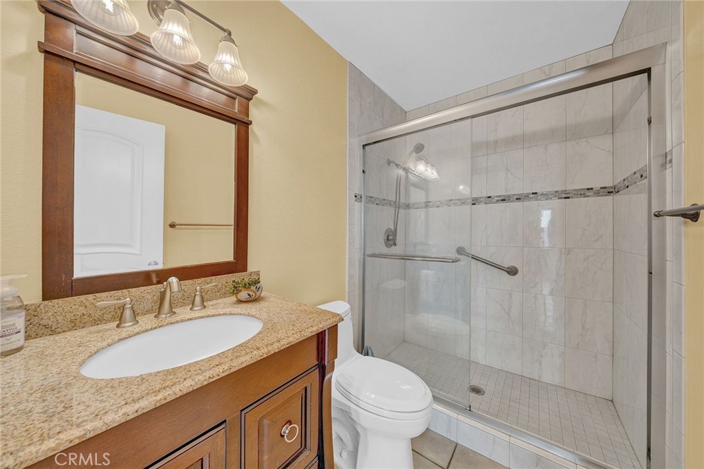 23419 Sandridge Road Diamond Bar, CA 91765 - Photo 36 of 51 a bathroom with a granite countertop sink mirror vanity shower and a toilet